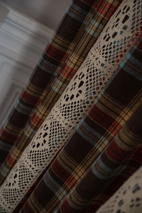 Detailed close-up of plaid fabric with beige crochet lace trim for farmhouse curtains