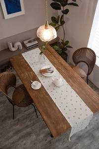 Close-up of lemon print table runner with tassels on a wooden dining table
