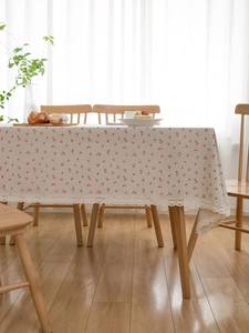 Detail of pink cherry floral linen tablecloth with delicate white lace trim on the hem