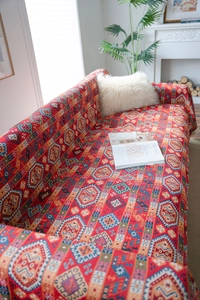 Close-up of red bohemian sofa cover with intricate ethnic patterns and thick jacquard fabric