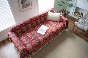 Detailed red bohemian sofa cover with ethnic jacquard pattern and white tassel fringe