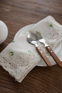 Detail of lemon pattern table runner with delicate white crochet lace on wood surface