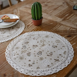 Tovagliette floreali in cotone e lino con bordo in pizzo su un tavolo di legno rustico