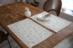 Close-up of rustic lemon print table mats with exquisite beige lace crochet borders