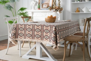 Detail of bohemian geometric jacquard tablecloth with handcrafted fringe tassels