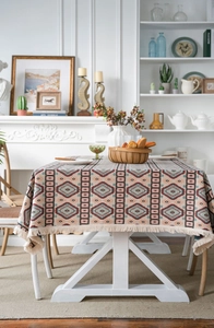 Close-up of bohemian geometric jacquard tablecloth with elegant cream tassel trim edges