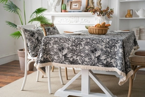 Detail of jungle animal pattern tablecloth with palm trees, leopards and fringe edges