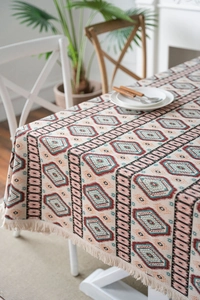 Detail of bohemian jacquard tablecloth featuring colorful geometric patterns and fringe edges