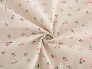 Close-up of pink cherry print on beige cotton linen fabric showing fine woven texture