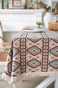 Detail of bohemian geometric woven tablecloth featuring fringe and thick jacquard texture