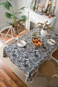 Close-up of black and white tropical jacquard tablecloth with fringe edge and leopard print