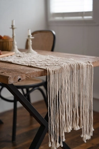 Detail shot of boho macrame table runner featuring complex hand-woven knots and long fringes