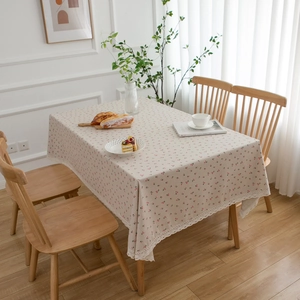 Pastoral cherry print table cloth with white lace edge on a wooden dining table