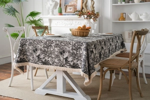 Detail of black and white Toile de Jouy table cloth with tropical forest and fringe