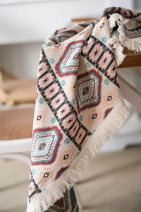 Close-up of Bohemian jacquard tablecloth with colorful geometric patterns and fringe