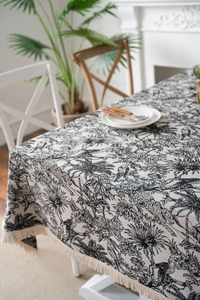 Detail of thick fabric tablecloth with black jacquard forest animal motifs and tassels