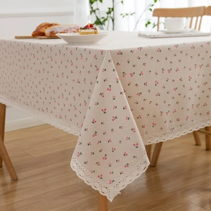 Linen table cloth with cherry print and white lace trim in a cozy dining setting