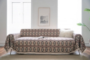 Detail of bohemian geometric jacquard sofa cover with fringe edges and thick texture