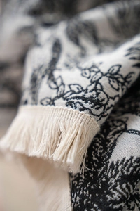 Detail of Toile de Jouy jacquard pattern with handmade tassel fringe on thick tablecloth