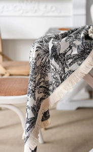 Detailed macro view of black and white tropical jacquard fabric with thick cream tassels