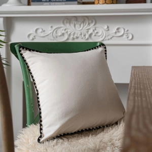 Minimalist cream cotton linen pillow case with black scalloped trim on vintage chair