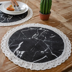 Round marble print table mats with white lace edges on a wooden dining table