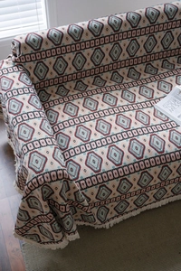Close-up of bohemian geometric jacquard throw cover with white twisted tassel fringe