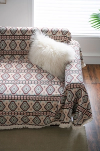 Detail of American vintage sofa throw with geometric jacquard pattern and fringes