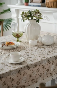 Close-up of dandelion print tablecloth with elegant white lace border detail
