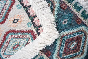 Detailed close-up of Bohemian geometric jacquard fabric with soft white fringe tassels