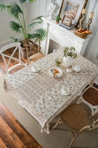 Detail of hollow lace stitching and dandelion print on beige linen rectangular tablecloth