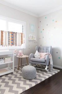 Detail of bohemian geometric print curtain with colorful pom-pom tassels in a nursery