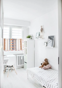 Detail of bohemian geometric print curtain with colorful pompom trim and cotton linen texture