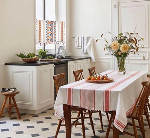Detail of bohemian kitchen cafe curtain with geometric prints and colorful pom-poms