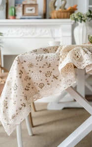 Detail of pastoral beige tablecloth featuring dandelion floral prints and crochet lace edges