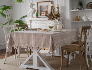 Detail of embroidered stripes and beige fringe on a rustic American style tablecloth