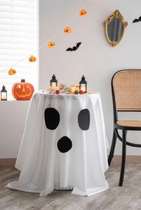 Detail of white ghost Halloween tablecloth featuring black eyes on smooth fabric