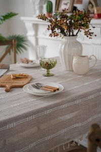Detailed macro view of brown striped tablecloth with bow patterns and delicate tassels