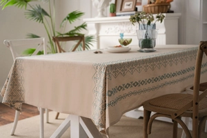 Detail view of cotton linen tablecloth with teal geometric embroidery and fringe