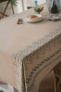 Detail of blue geometric embroidery on natural beige cotton-linen blend tablecloth