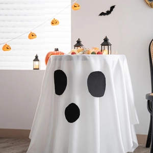 Ghost face Halloween tablecloth for party decoration on a white round table