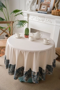 Close-up of thick beige tablecloth with dark blue floral jacquard pleated edge detail