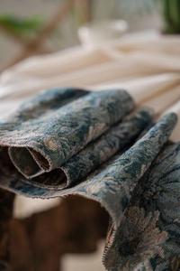 Macro detail of heavy blue floral jacquard fabric with premium vintage woven texture
