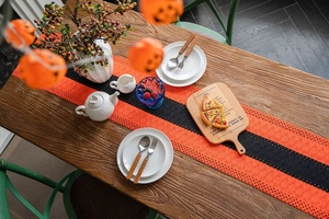 Close-up of orange and black knitted Halloween table runner with hollowed-out patterns