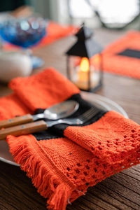 Detail showing handwoven cotton Halloween table runner with tassels and hollow-out design