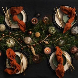 Nordic dinnerware set with matte plates and orange linen napkins for festive dining