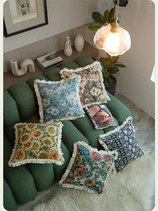 Detail of vintage jacquard throw pillow covers featuring floral patterns and fringe edges