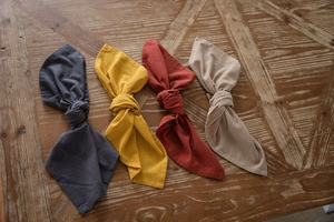 Detail of four-color washed cotton napkins with rustic knot design on wooden table