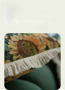 Detail of vintage floral jacquard pillow cover with cream cotton fringe tassels