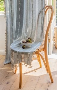 Light blue striped curtain with white geometric embroidery and delicate fringe tassels